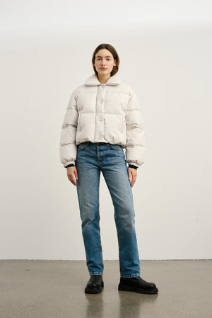 A model wears a light gray puffer jacket paired with blue jeans and black boots, showcasing MEOTINE's stylish winter outerwear.
