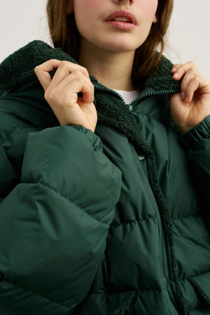A model wearing a cozy green MEOTINE puffer jacket with a soft, textured collar, showcasing a stylish and warm look.