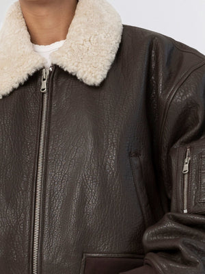 Brown leather bomber jacket with a cozy cream faux fur collar, showcasing a stylish and warm design by MEOTINE.