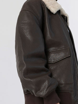 Brown leather jacket with a cozy shearling collar, featuring a zip closure and side pockets, by MEOTINE.