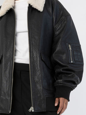 Stylish black leather jacket with a cozy shearling collar, featuring a zippered pocket and relaxed fit, by MEOTINE.