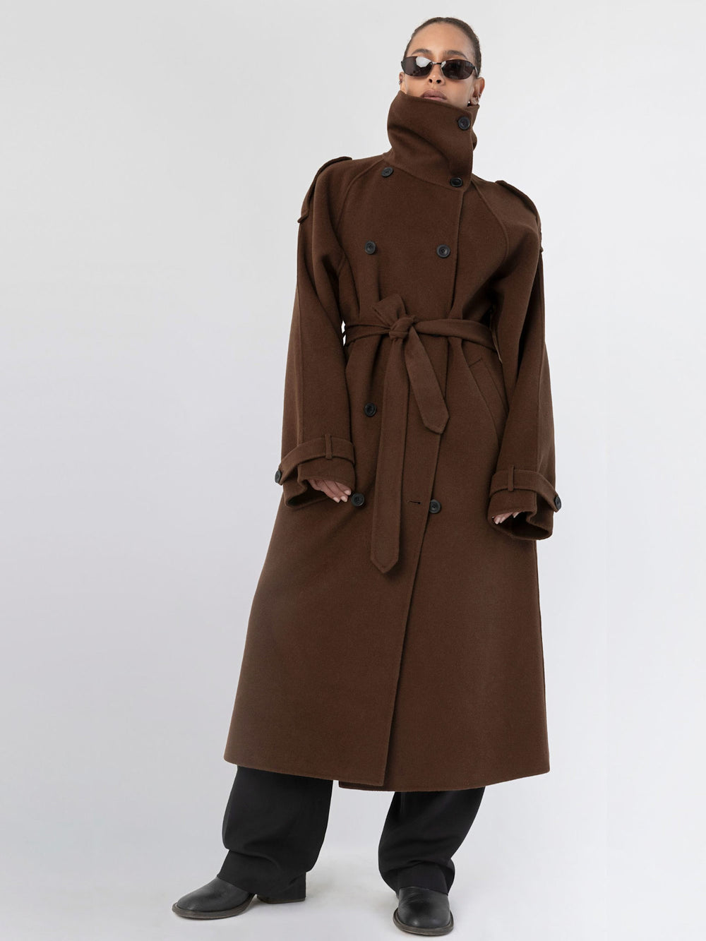 Brown double-breasted trench coat with a belt and shoulder epaulettes, showcasing a stylish and sophisticated design by MEOTINE.