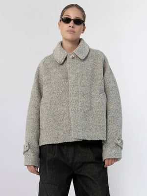A model wears a stylish, cropped gray jacket with a collar and button details, showcasing MEOTINE's contemporary design.