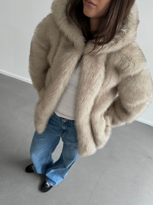 Cozy beige faux fur jacket with a hood, paired with a white top and blue jeans, showcasing a stylish look by MEOTINE.