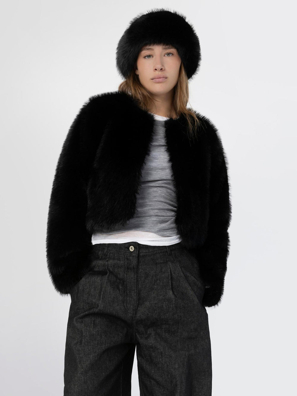 A model showcases a stylish black faux fur jacket paired with a matching hat, exuding elegance and warmth by MEOTINE.