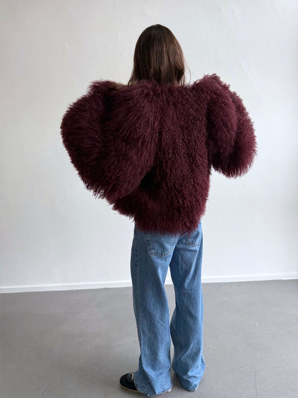 A model showcases a fluffy burgundy MEOTINE sweater paired with light blue jeans, highlighting a trendy, oversized silhouette.