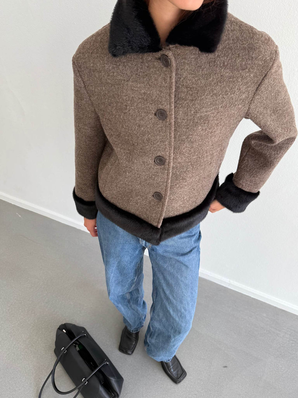 Stylish brown and black MEOTINE jacket with a faux fur collar, paired with blue jeans and a black handbag.