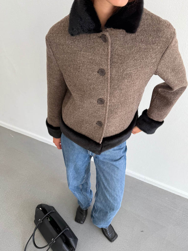 Stylish brown and black MEOTINE jacket with a faux fur collar, paired with blue jeans and a black handbag.