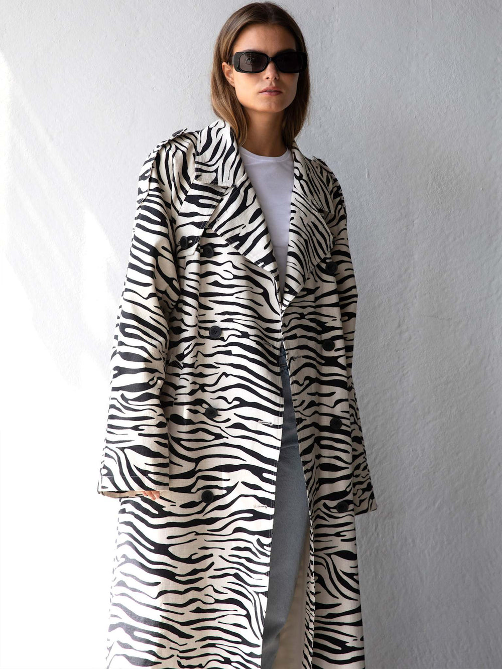 A model showcases a stylish zebra-striped coat, paired with a simple white tee and sunglasses, embodying MEOTINE's chic aesthetic.