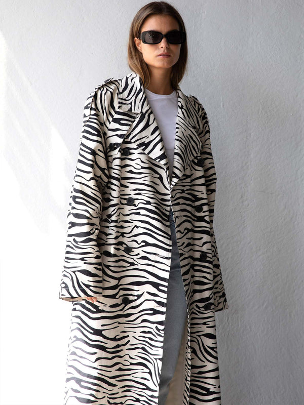 A model showcases a stylish zebra-striped coat, paired with a simple white tee and sunglasses, embodying MEOTINE's chic aesthetic.