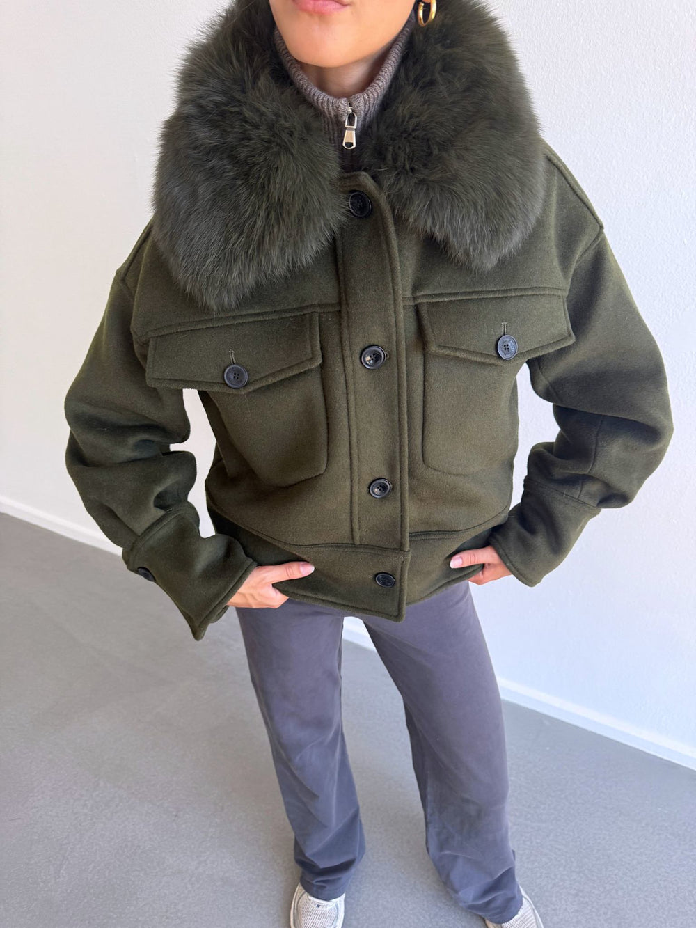 Stylish olive green cropped jacket with a plush fur collar and front pockets, perfect for a chic winter look by MEOTINE.
