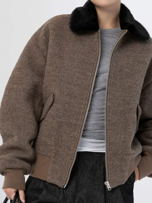 Brown bomber jacket with a black fur collar, featuring a zip closure and side pockets, styled with a casual gray top. MEOTINE.