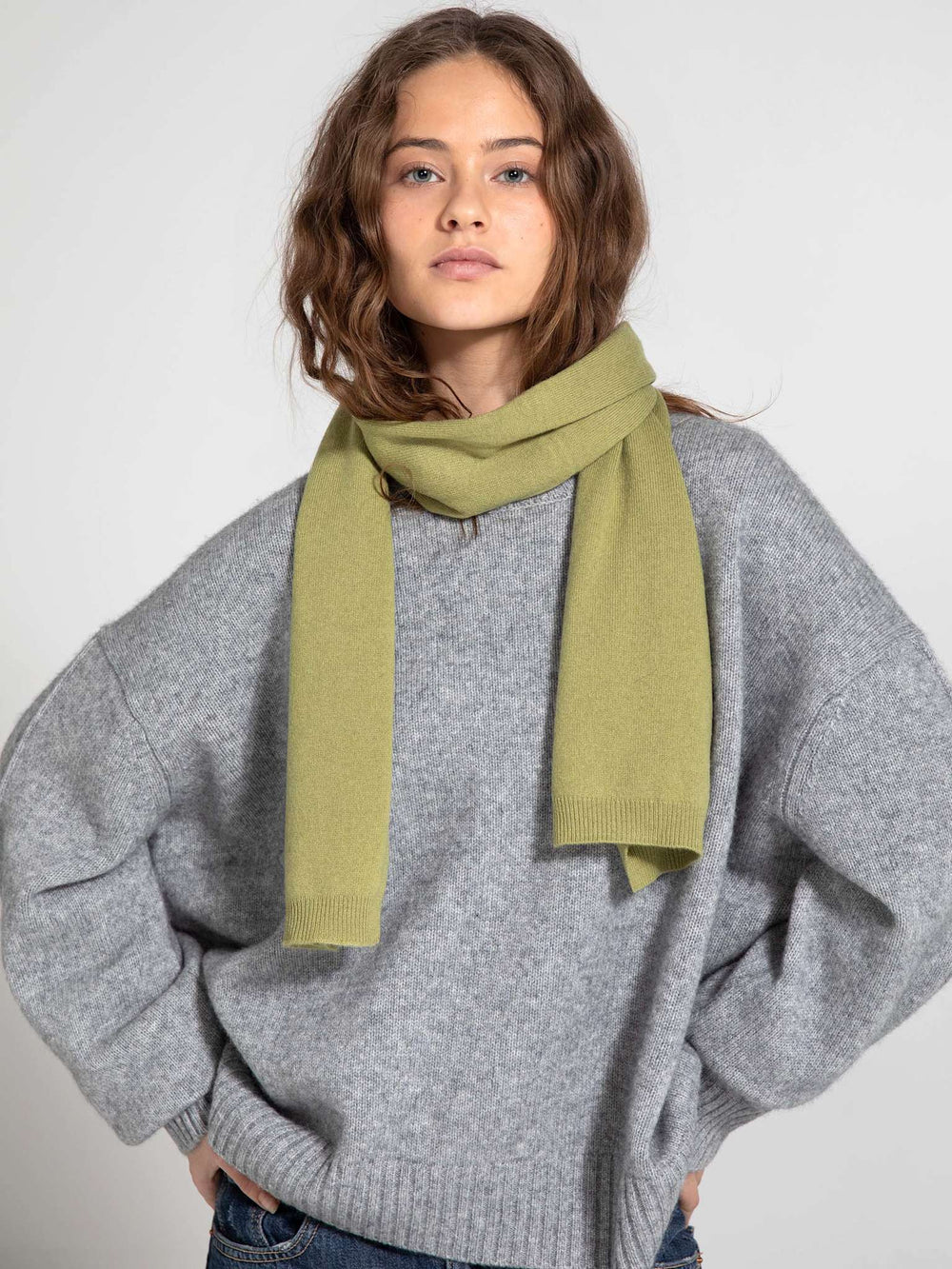 A model wearing a cozy gray oversized sweater with a soft green scarf, showcasing MEOTINE's stylish winter collection.