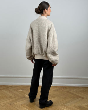 Cozy oversized cream sweater with textured fabric, paired with black pants, showcasing a relaxed style by MEOTINE.