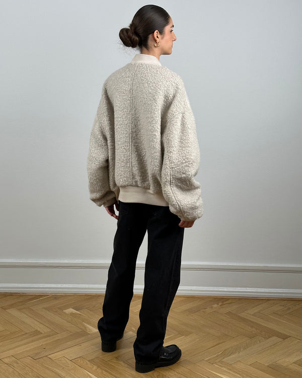Cozy oversized cream sweater with textured fabric, paired with black pants, showcasing a relaxed style by MEOTINE.