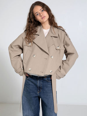 A model poses in a stylish beige cropped trench coat with a double-breasted design, showcasing MEOTINE's modern aesthetic.