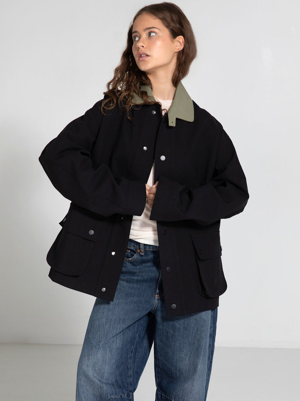 A model showcases a stylish oversized black jacket with a contrasting green collar, embodying MEOTINE's modern aesthetic.