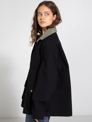 A model showcases a stylish oversized black jacket with a contrasting green collar, embodying MEOTINE's modern aesthetic.
