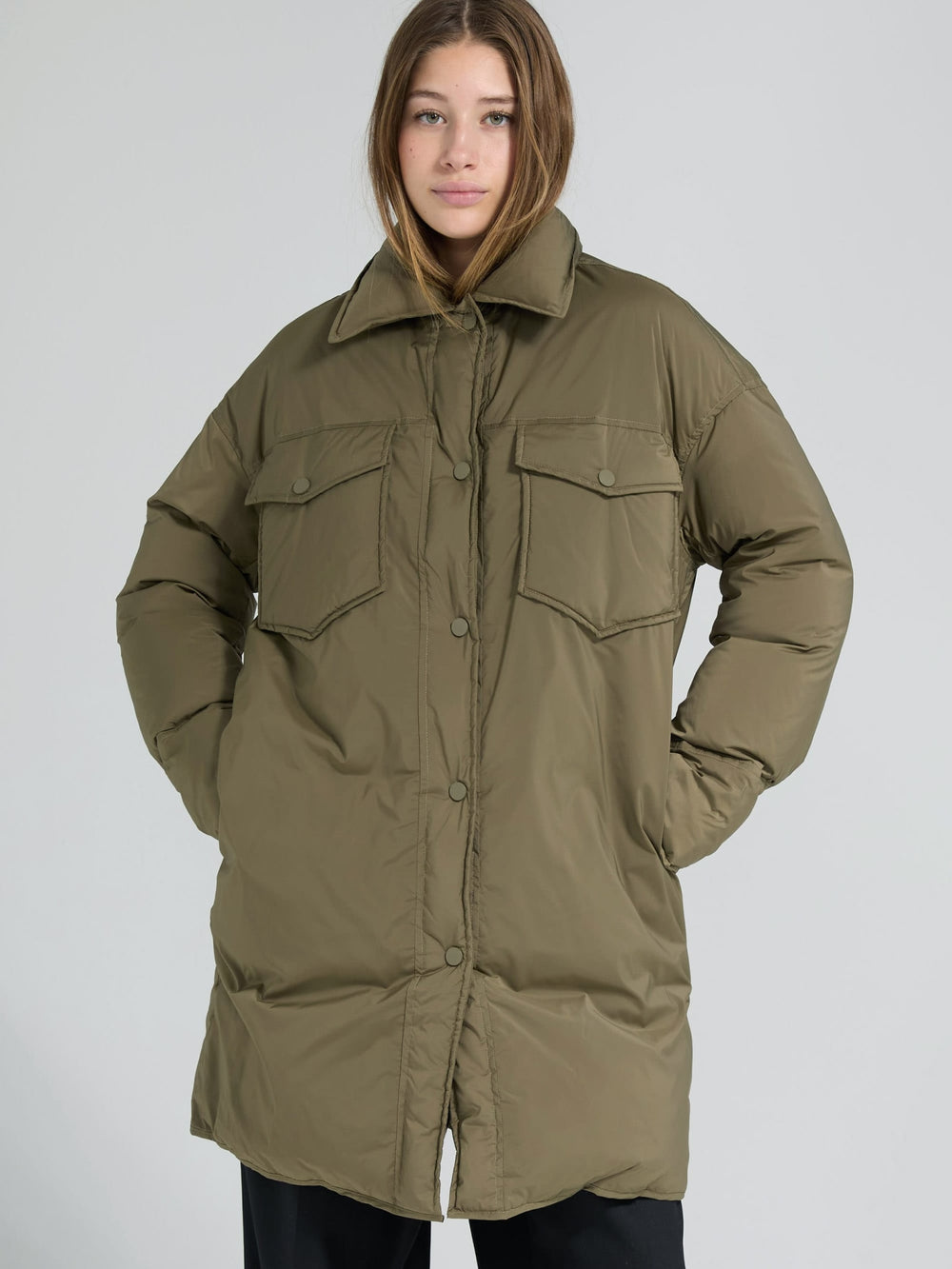 A model wears a stylish olive green oversized puffer coat with large pockets, showcasing MEOTINE's trendy winter fashion.