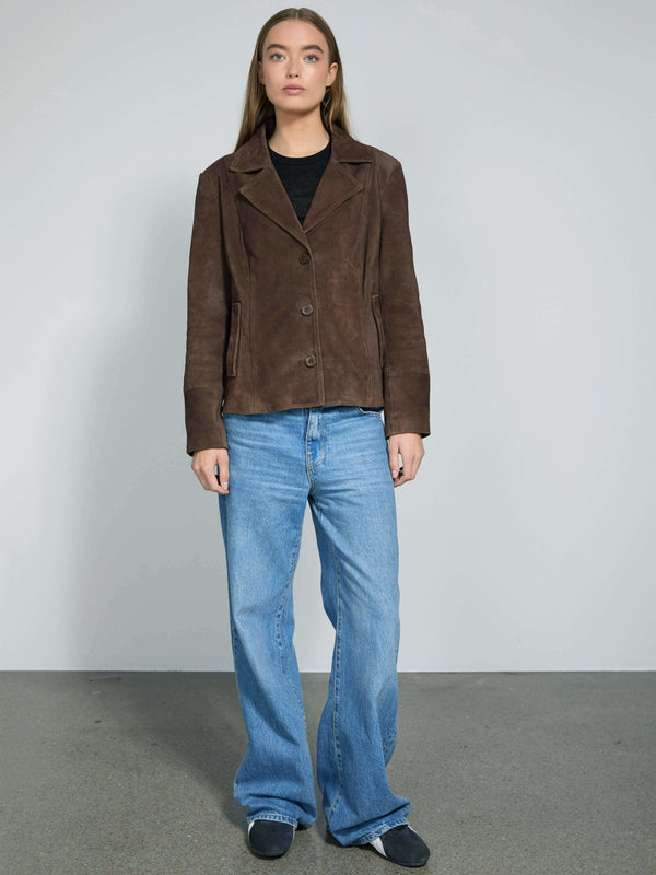 A model stands confidently in a brown suede jacket paired with light blue wide-leg jeans, showcasing MEOTINE's stylish design.