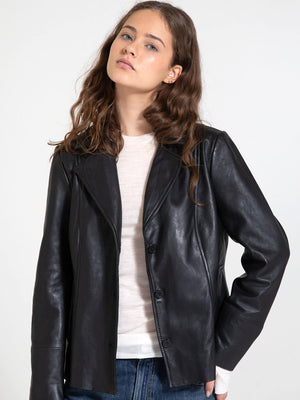 A model showcases a stylish black leather jacket from MEOTINE, featuring a tailored fit and button closure, perfect for any occasion.