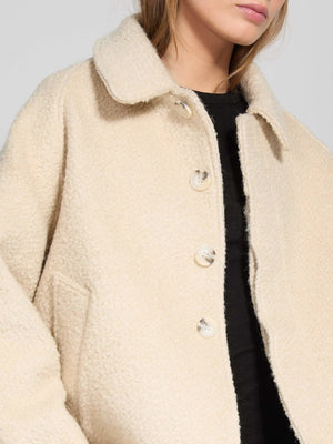 A model wears a cozy beige MEOTINE jacket with a collared neckline and button closure, perfect for stylish layering.