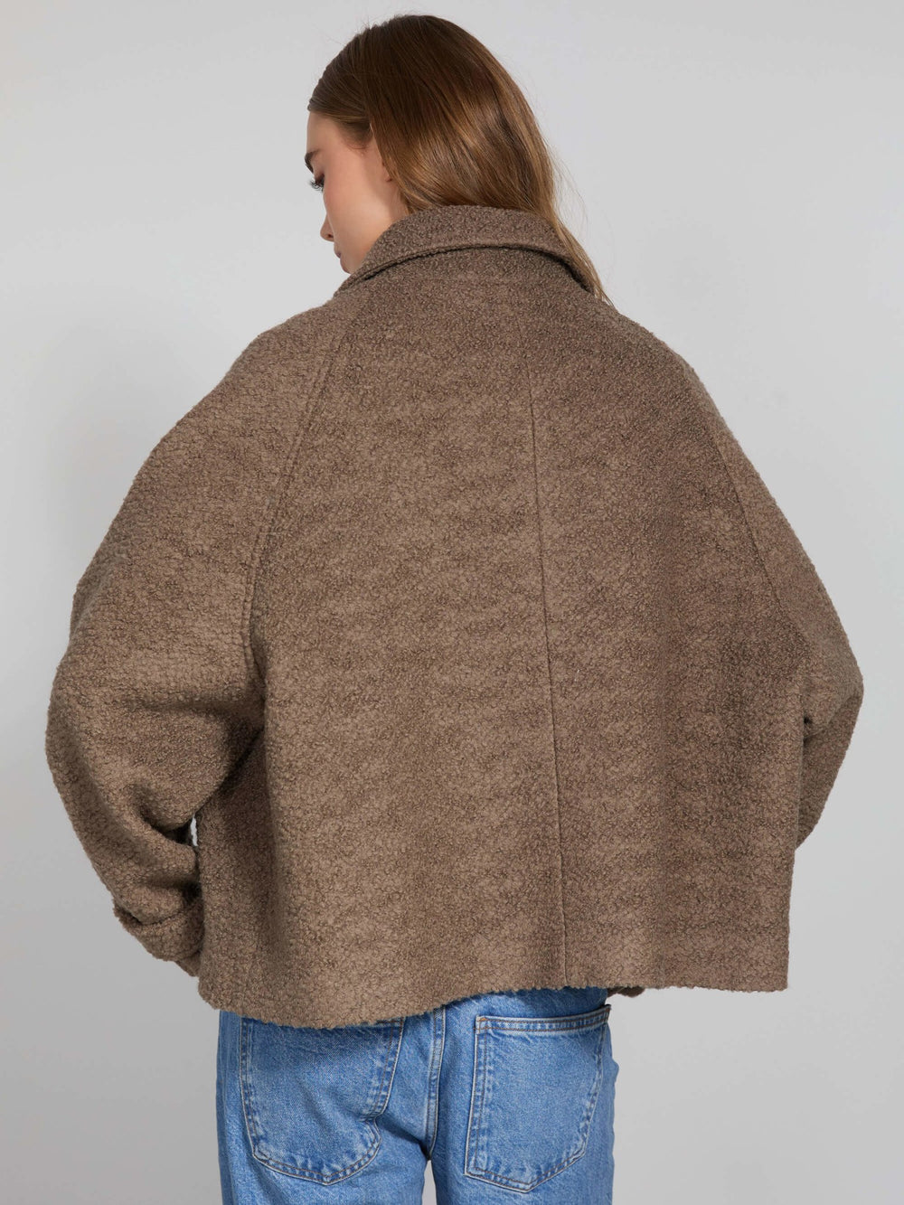 A model wears a cozy brown MEOTINE jacket with a relaxed fit, featuring a collared neckline and button closure, styled with jeans.