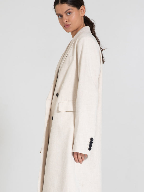 A model showcases a stylish beige long coat with a relaxed fit and button details, embodying the elegance of MEOTINE.
