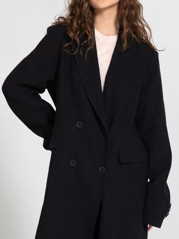 A model showcases a stylish dark navy double-breasted coat from MEOTINE, featuring a relaxed fit and elegant design.