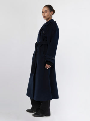 A model showcases a stylish navy blue trench coat with a belt, featuring a tailored fit and elegant design by MEOTINE.