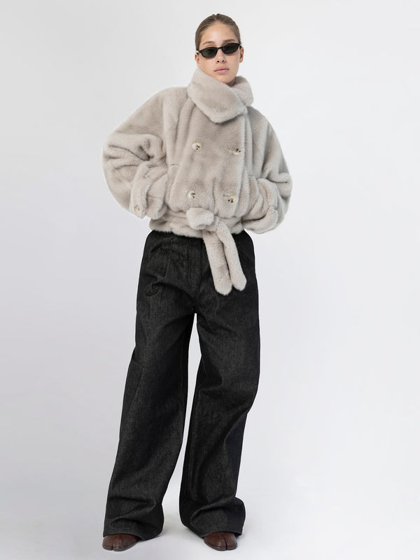 A model showcases a stylish MEOTINE faux fur jacket paired with wide-leg black trousers and trendy sunglasses.