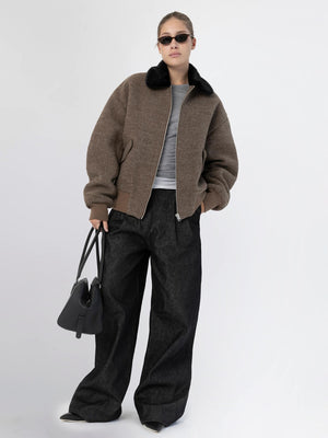 Stylish model wearing a brown bomber jacket with a black fur collar, paired with wide-leg jeans and sunglasses, showcasing MEOTINE fashion.