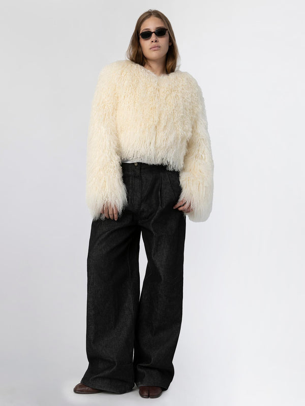 A model wears a fluffy white MEOTINE sweater paired with oversized black jeans, exuding a chic and cozy vibe.