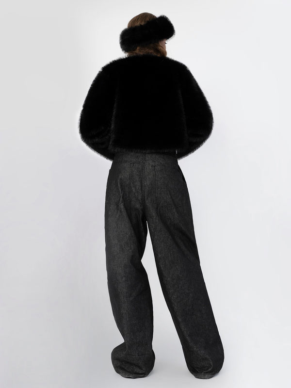 A model wearing a black faux fur jacket and wide-leg black pants, showcasing a chic and cozy look by MEOTINE.