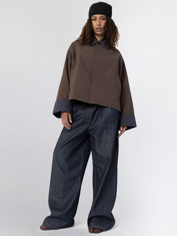 A model showcases a stylish brown cropped jacket with oversized sleeves and wide-leg denim pants, embodying MEOTINE's modern aesthetic.