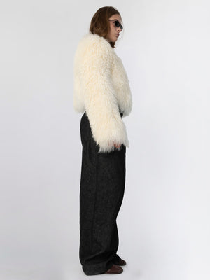 A model showcases a fluffy white MEOTINE jacket paired with high-waisted black trousers, exuding a chic and modern style.