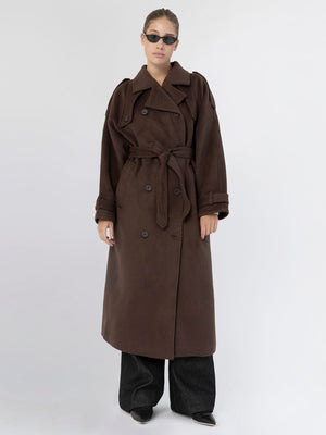 A model wears a stylish brown trench coat with a belt, paired with dark wide-leg pants and sunglasses, showcasing MEOTINE's chic design.