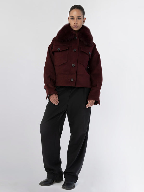 A model showcases a burgundy MEOTINE jacket with a fur collar, paired with loose black trousers against a neutral background.