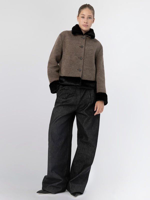 A model showcases a stylish brown cropped jacket with a black fur collar, paired with wide-leg black trousers, representing MEOTINE.