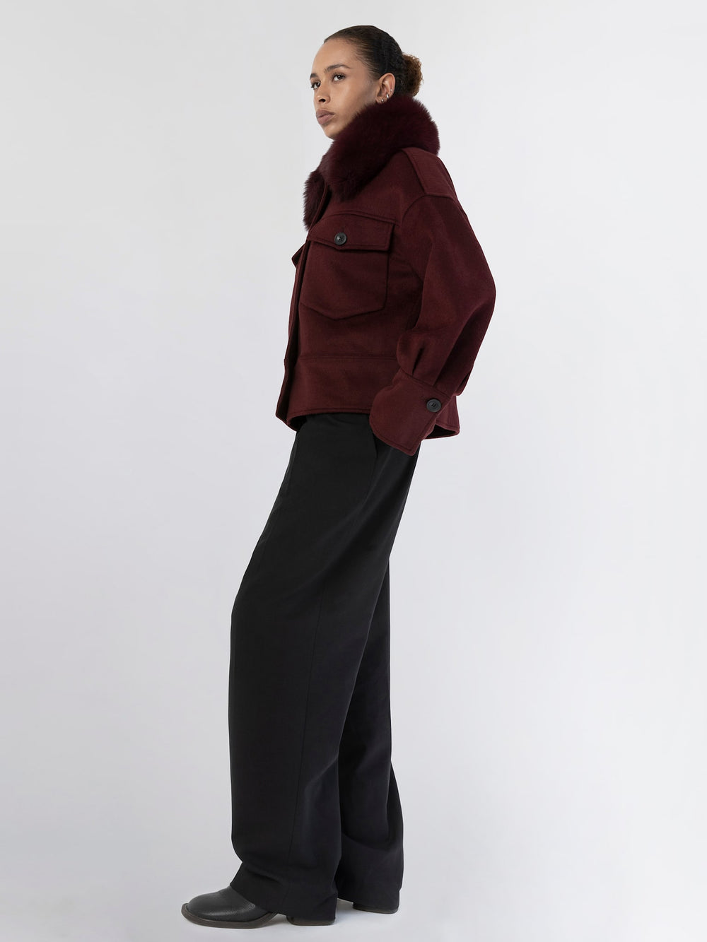 A model showcases a stylish burgundy jacket with a fur collar, featuring large pockets and a relaxed fit, by MEOTINE.