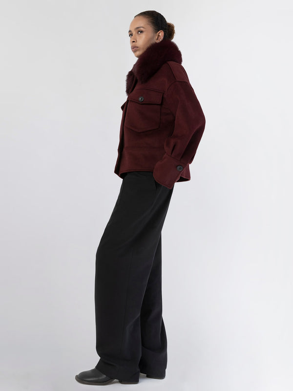 A model showcases a stylish burgundy jacket with a fur collar, paired with wide-leg black trousers, embodying MEOTINE's chic aesthetic.