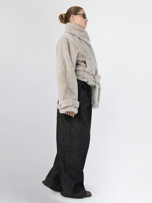 A model showcases a stylish MEOTINE oversized faux fur jacket paired with wide-leg black trousers, exuding modern elegance.