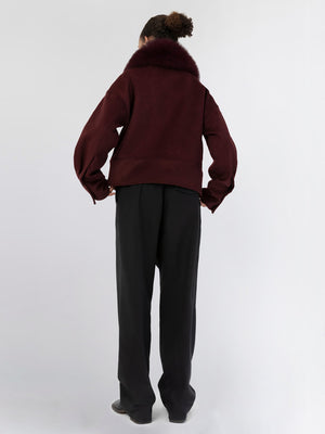 A model showcases a burgundy oversized jacket with a plush fur collar, paired with black wide-leg trousers, embodying MEOTINE's chic style.