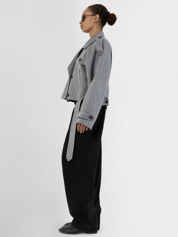 A model showcases a stylish gray cropped jacket with oversized sleeves, paired with black wide-leg pants, embodying MEOTINE's chic aesthetic.