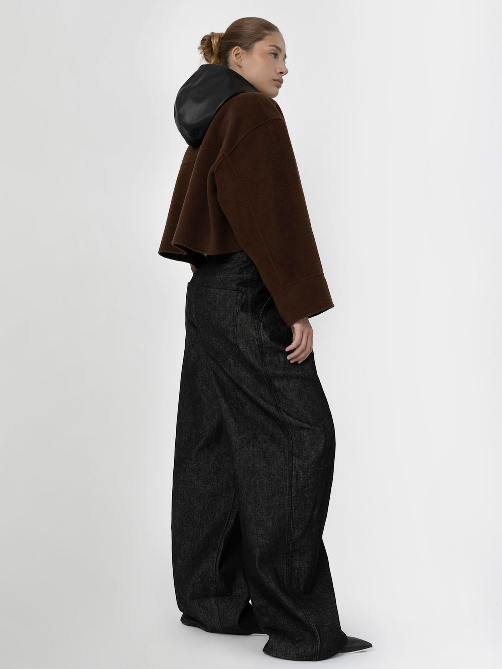A model wears a stylish brown cropped jacket with a zip and a black scarf, showcasing MEOTINE's modern design.