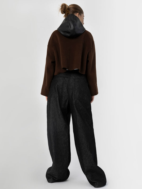 A model showcases a stylish brown cropped sweater with a black hood, paired with loose black trousers, representing MEOTINE's modern aesthetic.