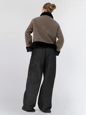 A model showcases a stylish brown and black cropped jacket paired with loose black trousers, embodying MEOTINE's chic aesthetic.
