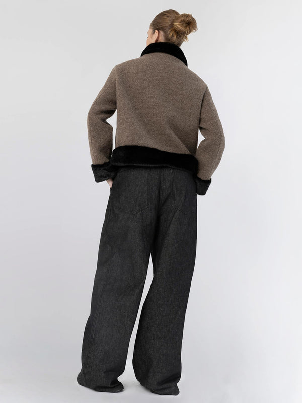 A model showcases a stylish brown and black cropped jacket paired with loose black trousers, embodying MEOTINE's chic aesthetic.