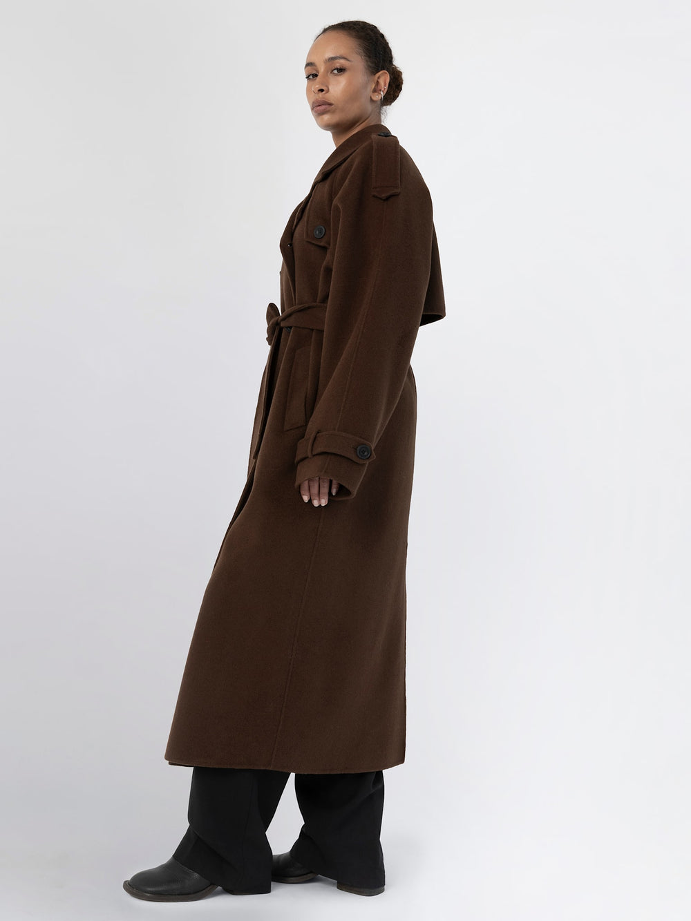A model showcases a brown oversized trench coat with a belt, featuring a classic design and relaxed fit, by MEOTINE.