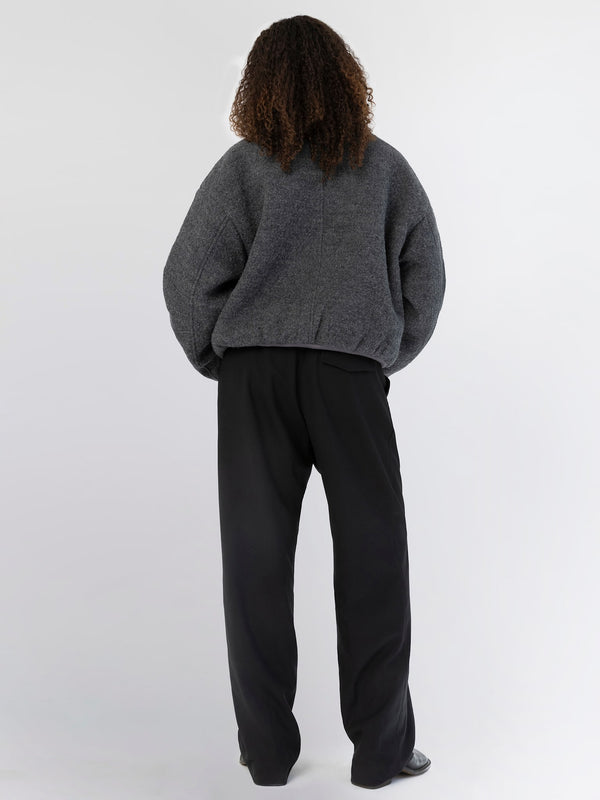 A model wearing a cozy gray oversized sweater and black wide-leg pants, showcasing a relaxed and stylish look by MEOTINE.